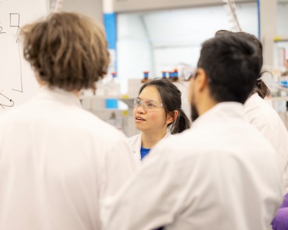 Group of employees in labcoats talking