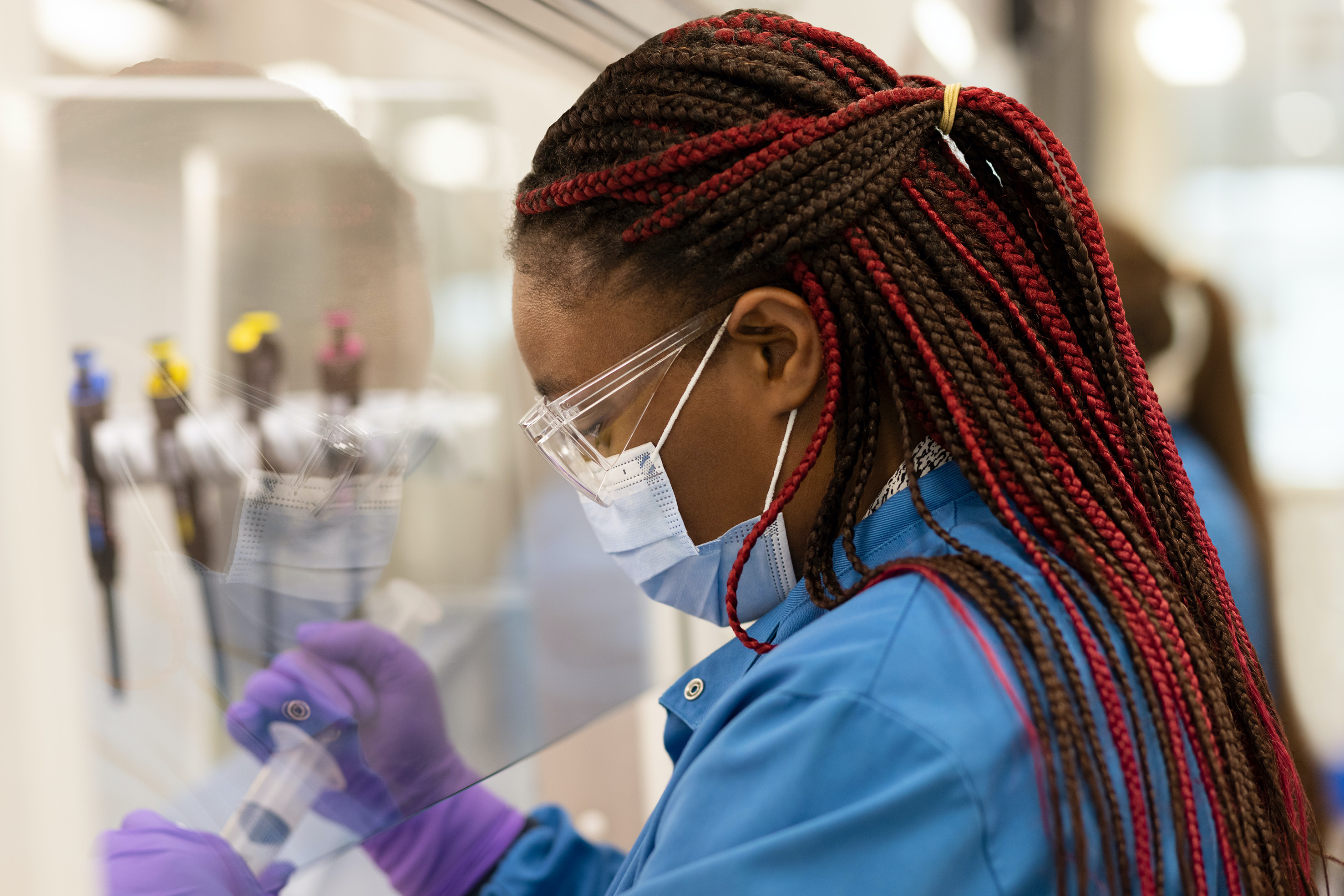 Scientist Using Syringe Behind Protective Screen Cover