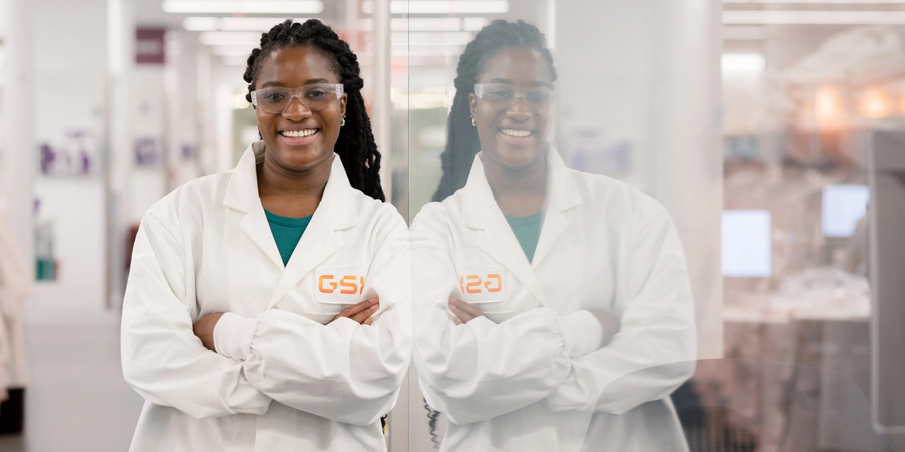 Smiling scientist leaning on wall