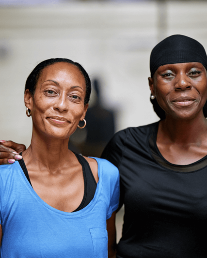 Two patients smiling with their arms round each other