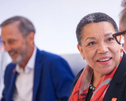 GSK Chair of Corporate Responsibility Committee Anne Beal smiles, Charles Bancroft in background